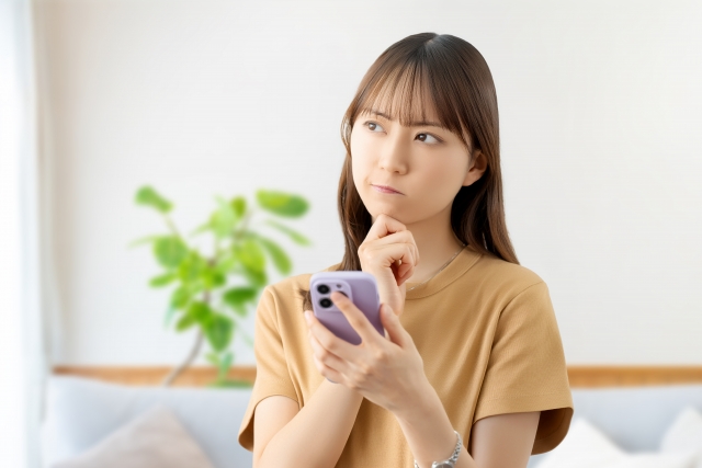 出産祝いにおもちゃのサブスクは迷惑かどうかスマホで検索して悩んでいる女性